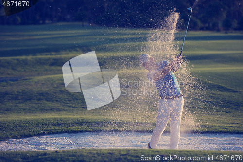 Image of golfer hitting a sand bunker shot on sunset