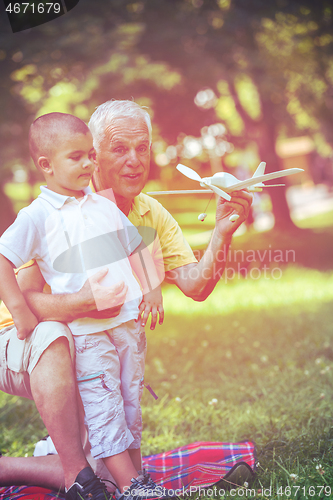 Image of grandfather and child have fun  in park