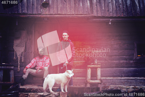 Image of frineds together in front of old wooden house