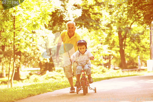 Image of grandfather and child have fun  in park