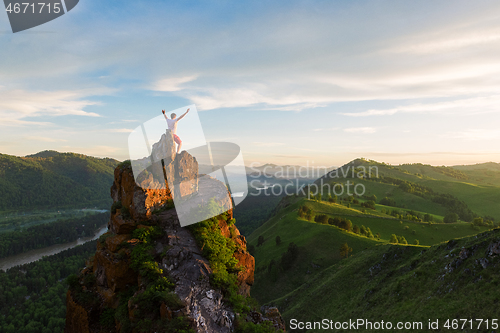 Image of Man standing on top of cliff