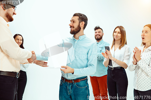 Image of Boss approving and congratulating young successful employee