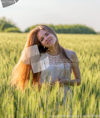 Image of Pretty girl in field at sunset