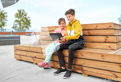 Image of children with tablet computer sitting on bench