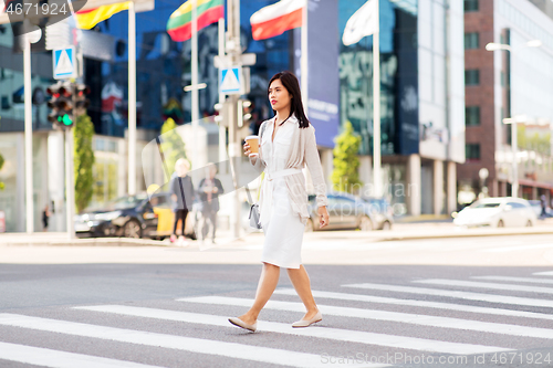 Image of asian woman with takeaway coffee cup in city