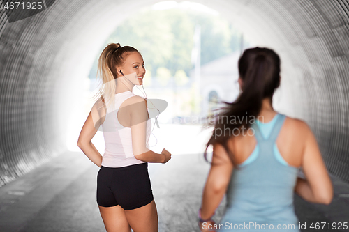 Image of women or female friends with earphones running