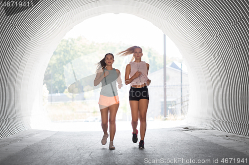 Image of women or female friends with earphones running