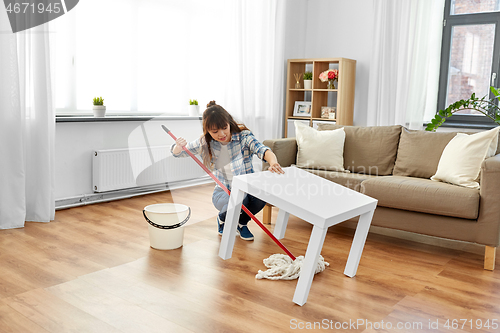 Image of woman or housewife with mop cleaning floor at home