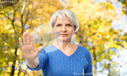 Image of senior woman making stop gesture in autumn park