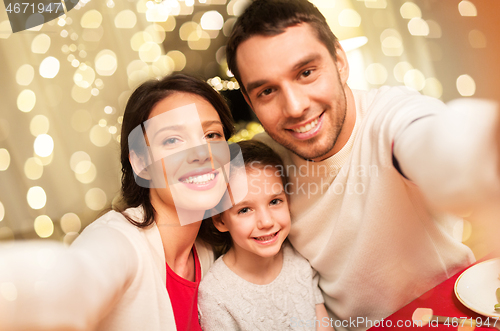 Image of happy family taking selfie at christmas