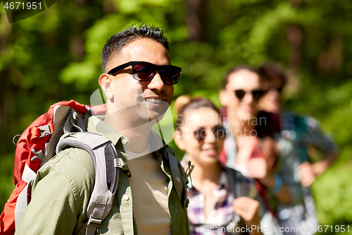 Image of group of friends with backpacks hiking in forest