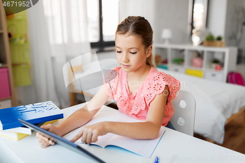 Image of student girl using tablet computer at home