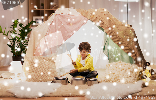 Image of boy with pots playing music in kids tent at home