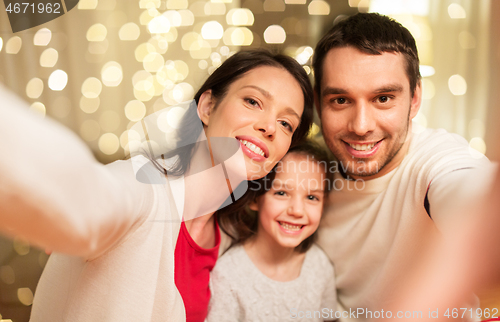 Image of happy family taking selfie at christmas