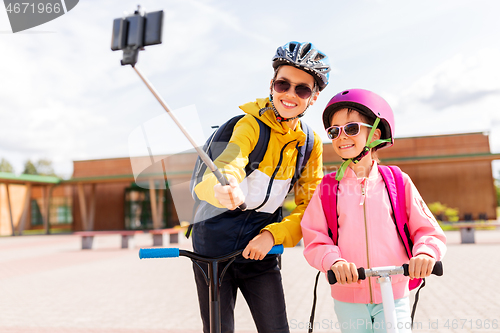 Image of happy school kids with scooters taking selfie