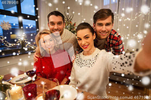 Image of friends taking selfie at christmas dinner