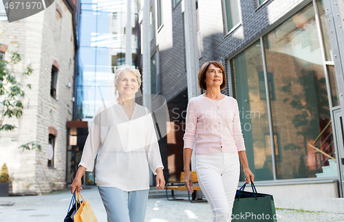 Image of senior women with shopping bags walking in city