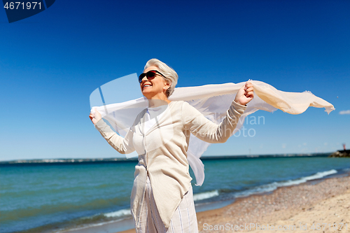 Image of senior woman with waving scarf on beach in estonia