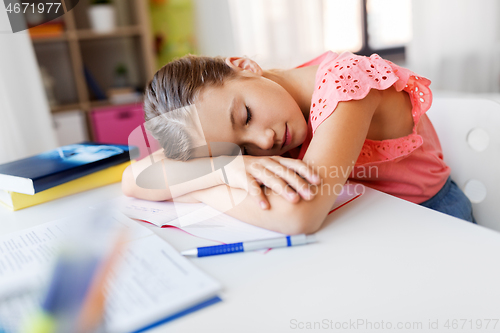 Image of tired student girl sleeping on table at home