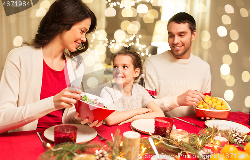 Image of happy family having christmas dinner at home