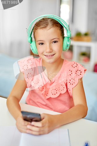 Image of girl in headphones listening to music on cellphone