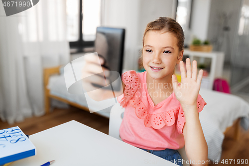 Image of happy girl with smartphone taking selfie at home