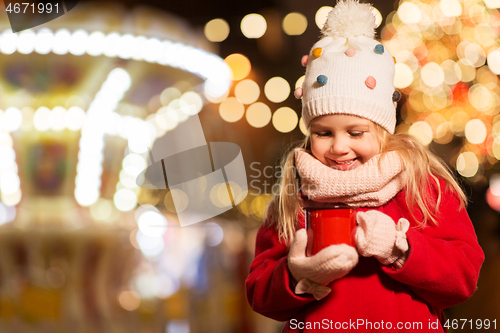 Image of happy girl with cup of tea at christmas market