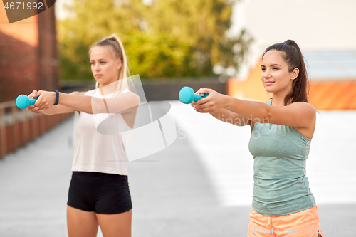 Image of women exercising with dumbbells outdoors