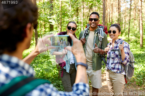 Image of friends with backpacks being photographed on hike