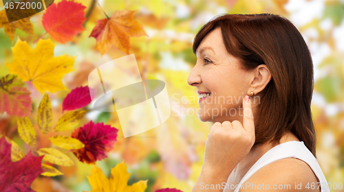 Image of smiling senior woman pointing to her earring