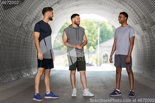 Image of young sporty men or male friends talking outdoors