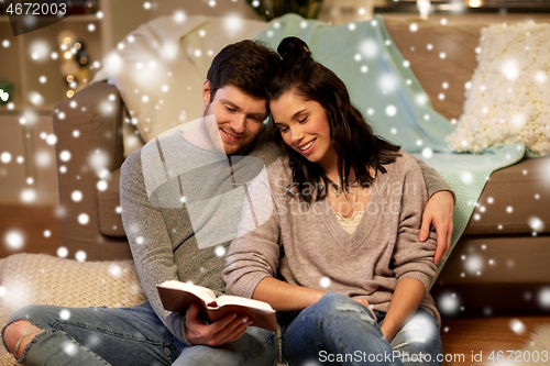 Image of happy couple reading book at home