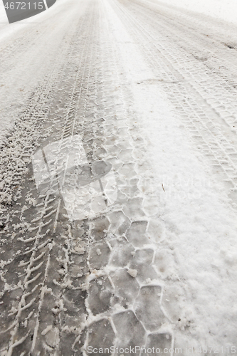 Image of car tire imprint on the snow melted