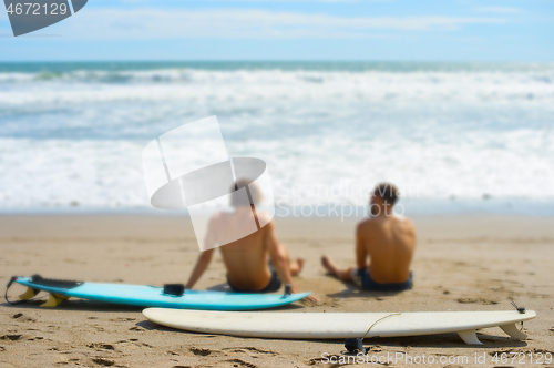 Image of Surfers rest on the beach