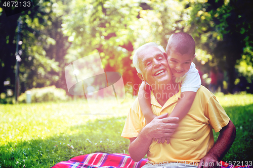 Image of grandfather and child have fun  in park