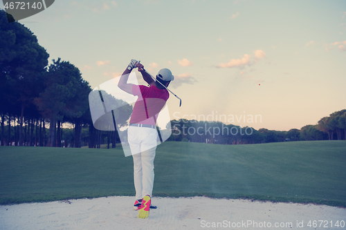 Image of golfer hitting a sand bunker shot on sunset