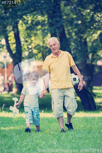 Image of grandfather and child have fun  in park