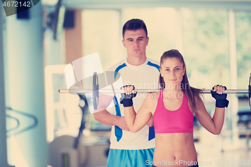 Image of young sporty woman with trainer exercise weights lifting