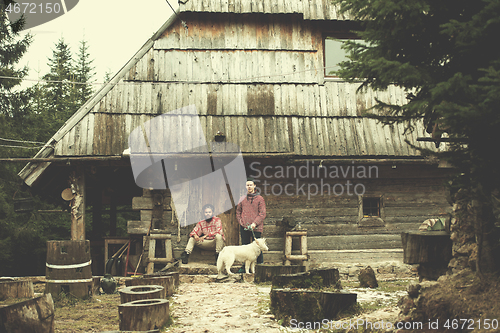 Image of frineds together in front of old wooden house