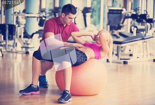 Image of young sporty woman with trainer exercise in fitness gym