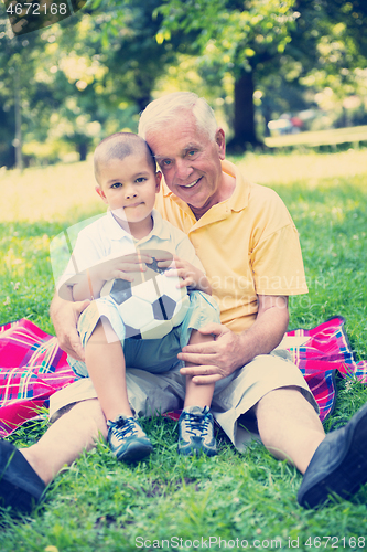 Image of grandfather and child have fun  in park