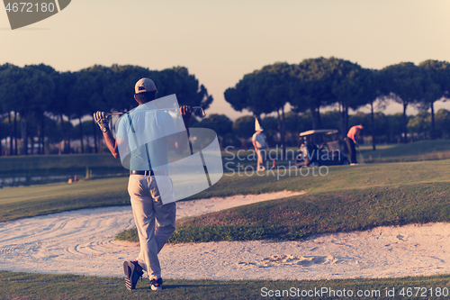 Image of golfer from back at course looking to hole in distance