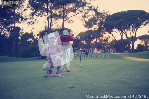 Image of couple on golf course at sunset