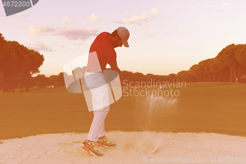 Image of golfer hitting a sand bunker shot on sunset