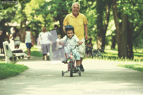 Image of grandfather and child have fun  in park