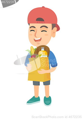 Image of Boy holding paper shopping bag full of groceries.