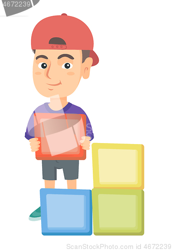 Image of Little caucasian boy playing with clourful cubes.
