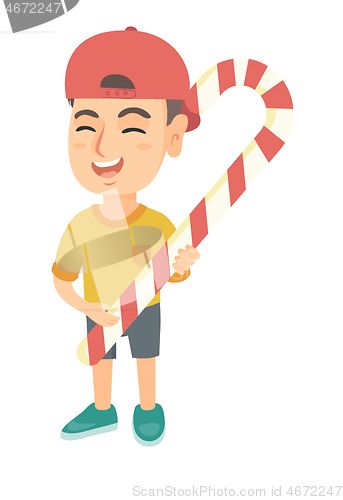 Image of Caucasian little boy holding christmas candy cane.
