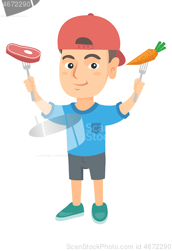 Image of Caucasian boy holding fresh carrot and steak.