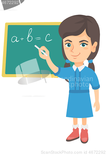 Image of Caucasian schoolgirl writing on the blackboard.
